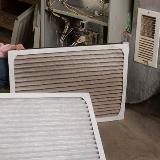 Old and dirty air filter next to clean filter in front of home furnace