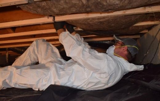 Low-Income Weatherization Program - person installing insulation in crawlspace of house
