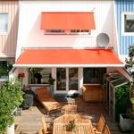 House with awnings above window and patio doors