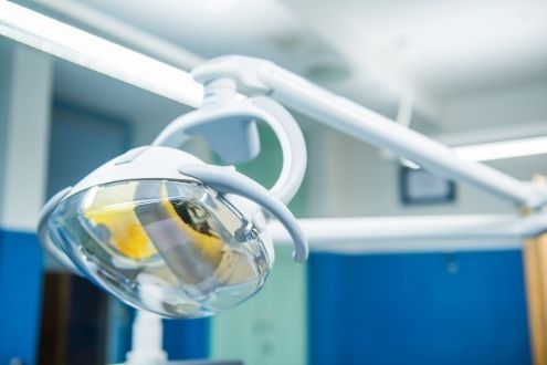 Dentist exam light with overhead lighting behind