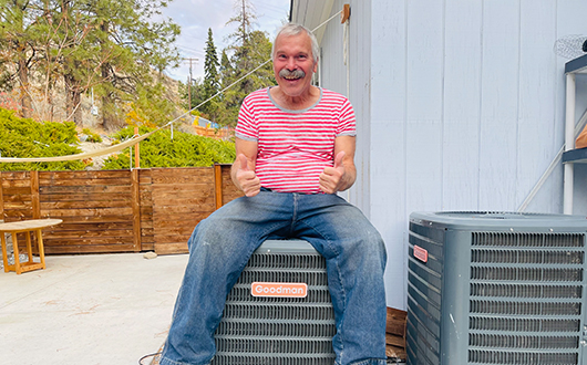 Mr. No One Ever sits on a heat pump giving two thumbs up