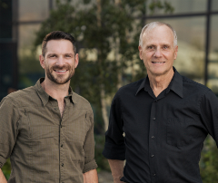 two men pose for a photo outside the Chelan PUD buildings