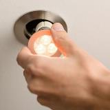 Close up of hand installing LED lightbulb