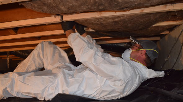 Crawlspace insulation added as part of the Low Income Weatherization Program person installs crawlspace insulation in home for low-income weatherization program