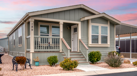 a manufactured home on a lot with sunset in the background