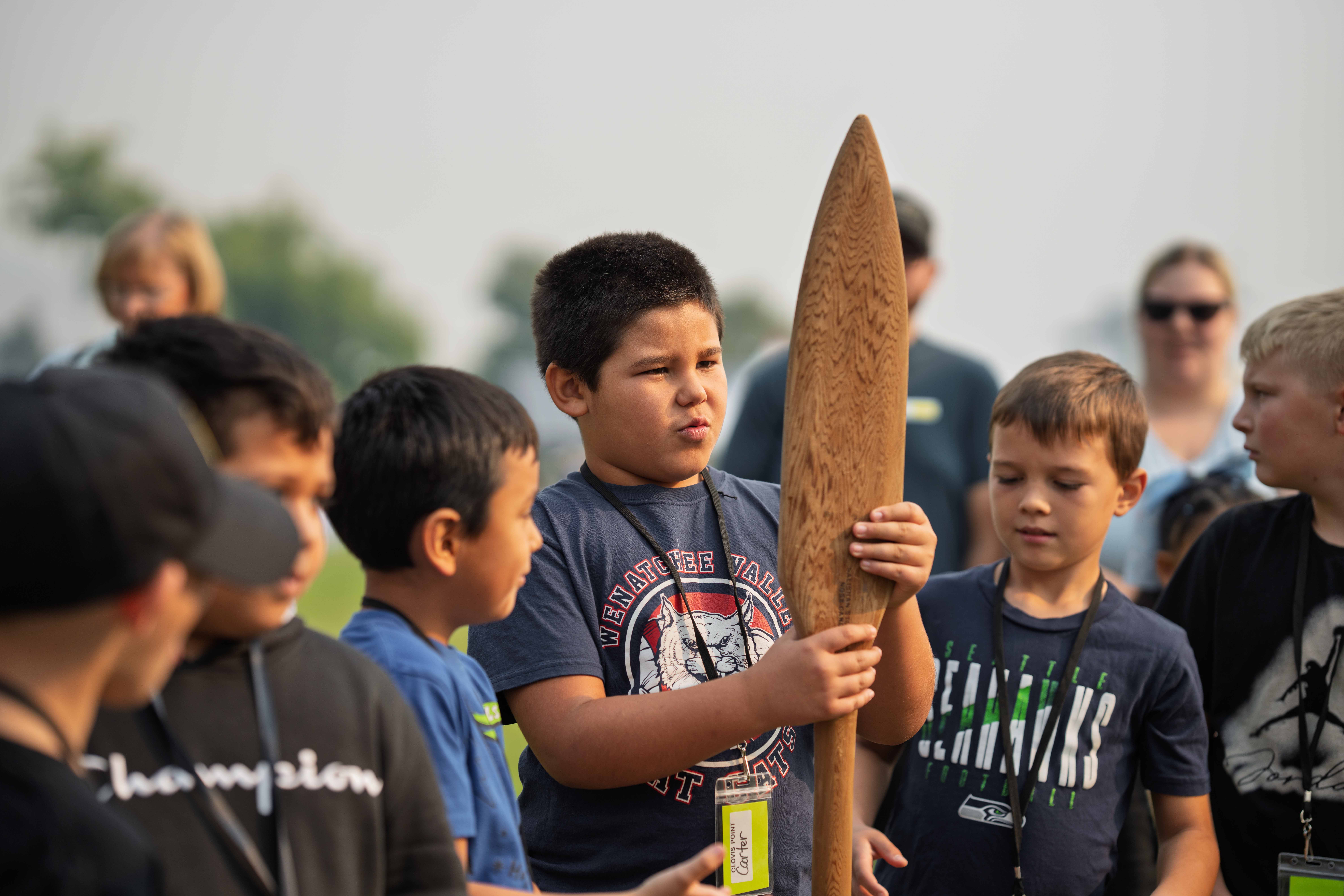 An Eastmont student admires a wooden oar at the Native American village, which will feature 45 Native American educators and exhibitors representing 11 tribes and bands