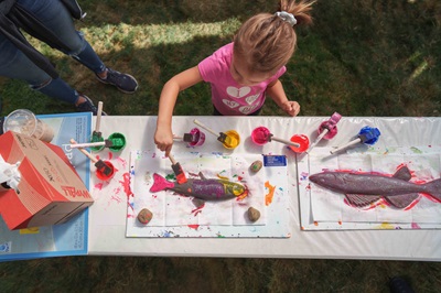 Salmonfest gyotaku A girl paints a silicone fish with tempura paint at the gyotaku fish print station at Wenatchee River Salmon Festival in 2025.