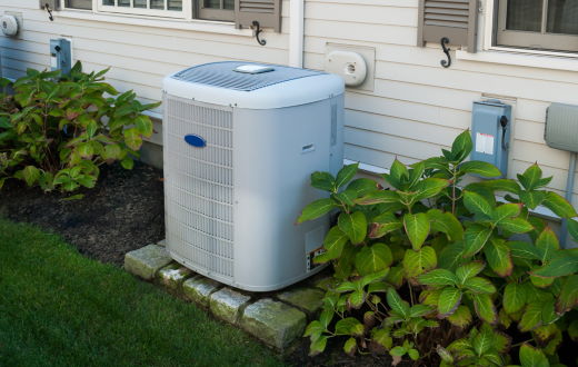 heat pump condenser unit outside home near lawn