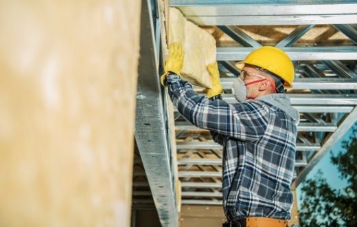 Man adding attic insulation to commercial building