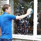 Person washing windows outside home